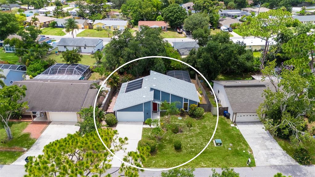 An aerial view shows a blue house with a gray roof and solar panels — 3944 PALAU DRIVE, SARASOTA, FL