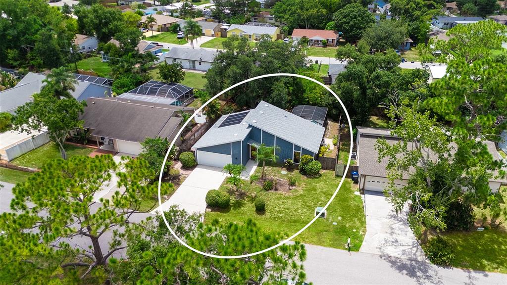 An aerial view shows a blue single-story house with solar panels and a screened patio — 3944 PALAU DRIVE, SARASOTA, FL