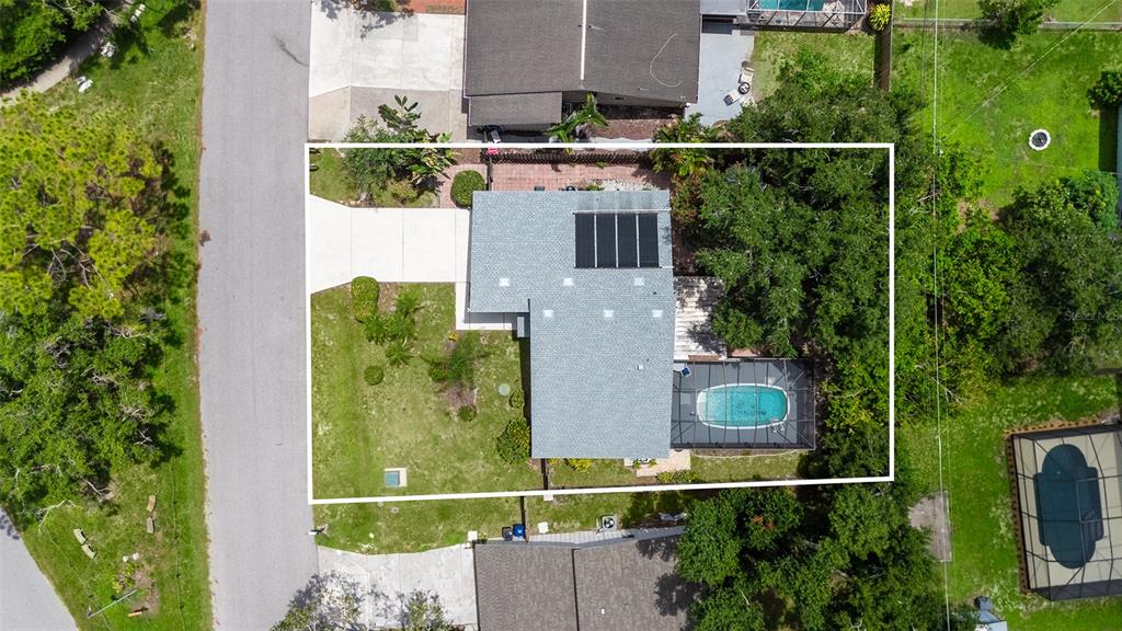 An aerial view shows a house with a solar panel array and a screened-in pool — 3944 PALAU DRIVE, SARASOTA, FL