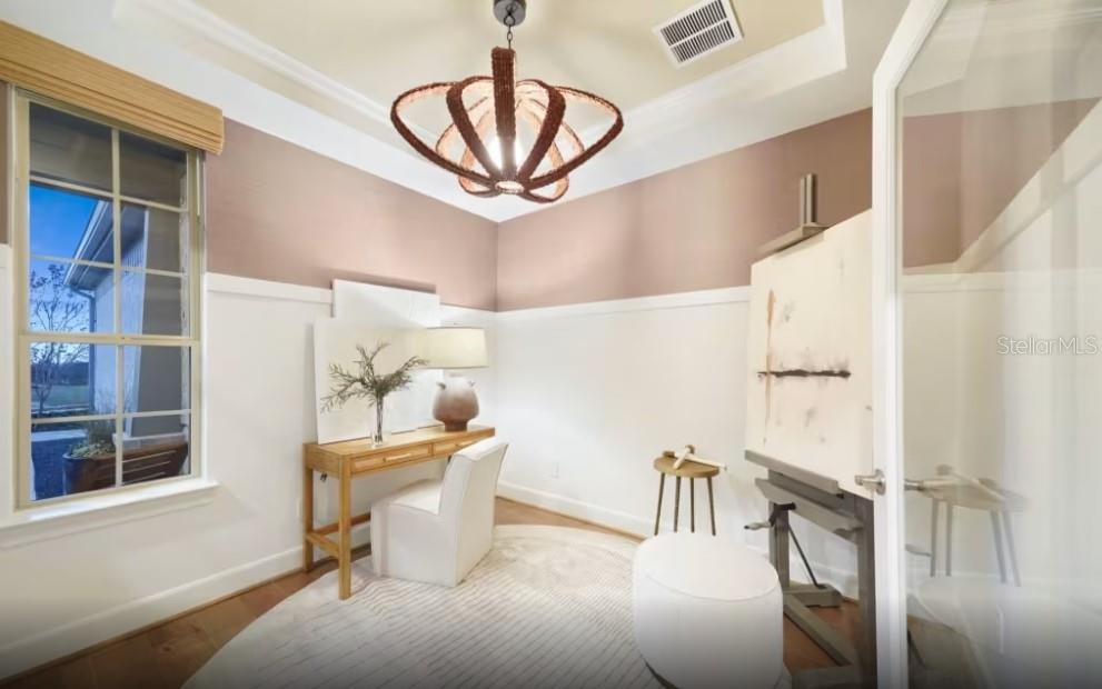 A home office features a wooden desk, an artist's easel, and a unique woven light fixture — 4782 W BLUE STAR COURT, NORTH PORT, FL