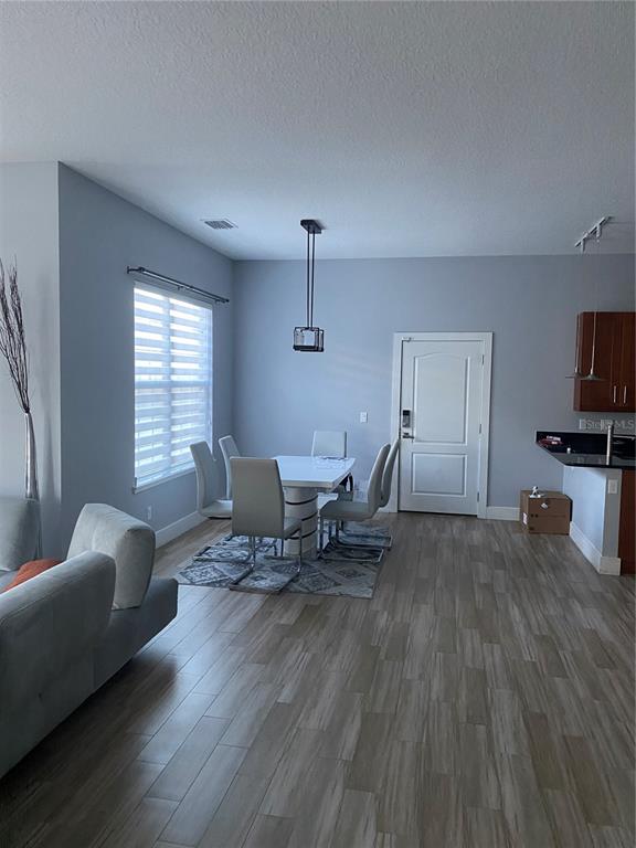 A dining area with a white table and chairs sits next to a living room — 2251 NAIRN DRIVE, WINTER PARK, FL