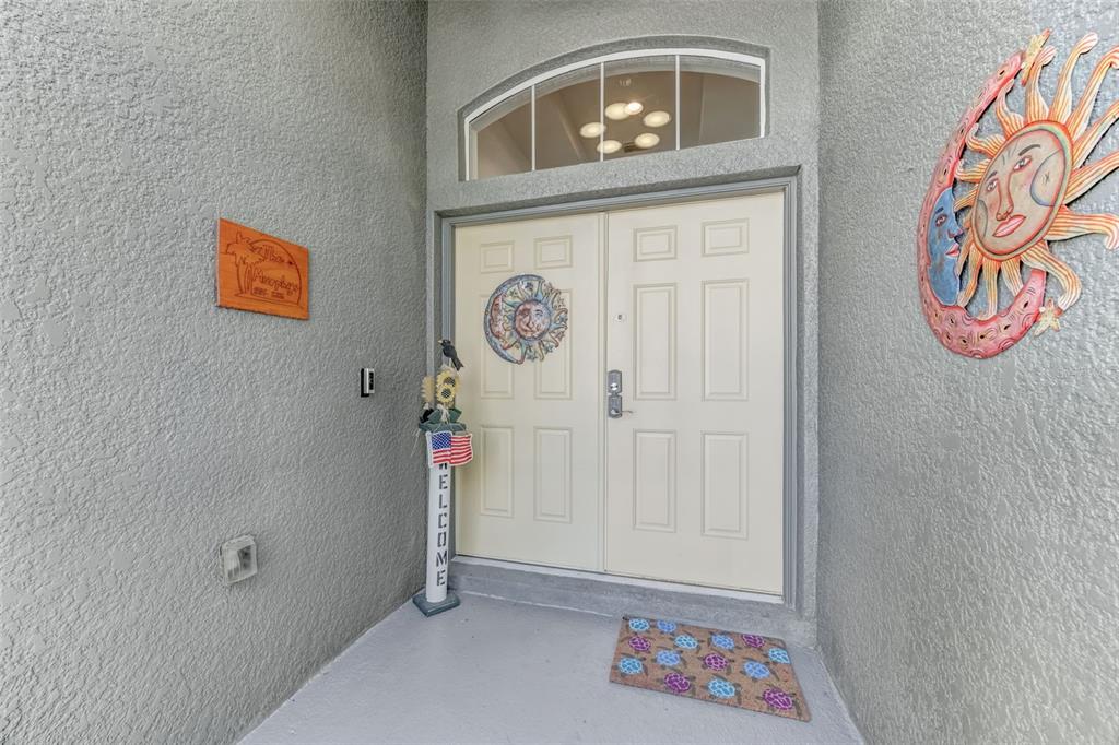 A light-colored double front door with a transom window and decorative wall art — 1511 BONITA BLUFF COURT, RUSKIN, FL