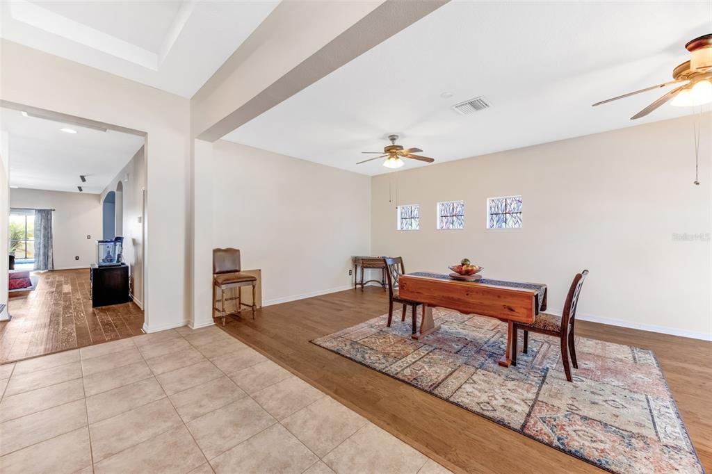 A dining area features wood flooring, a rug, a wooden table, and three small windows — 1511 BONITA BLUFF COURT, RUSKIN, FL