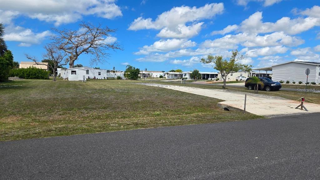A vacant lot with a concrete driveway sits in a residential mobile home community — 1464 BLUE HERON DRIVE, ENGLEWOOD, FL