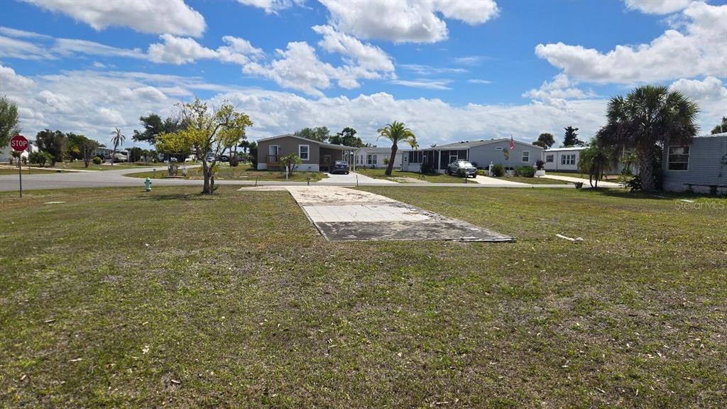 A vacant lot with a concrete pad sits in a residential mobile home community — 1464 BLUE HERON DRIVE, ENGLEWOOD, FL