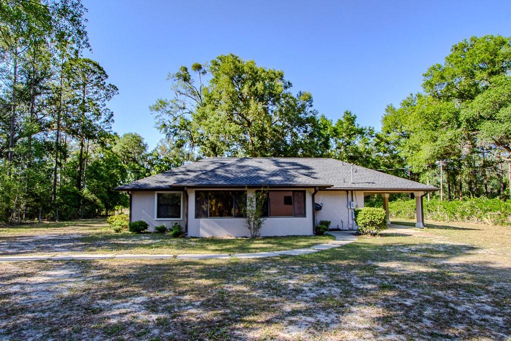 A single-story house with a light-colored exterior and a dark shingled roof sits outdoors — 4002 SW COUNTY ROAD 18, FORT WHITE, FL
