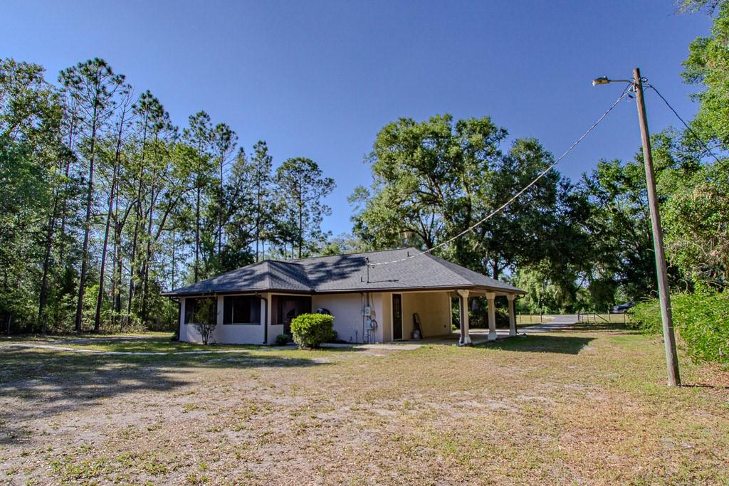 A single-story house with a hip roof and a covered porch sits on a grassy lot — 4002 SW COUNTY ROAD 18, FORT WHITE, FL