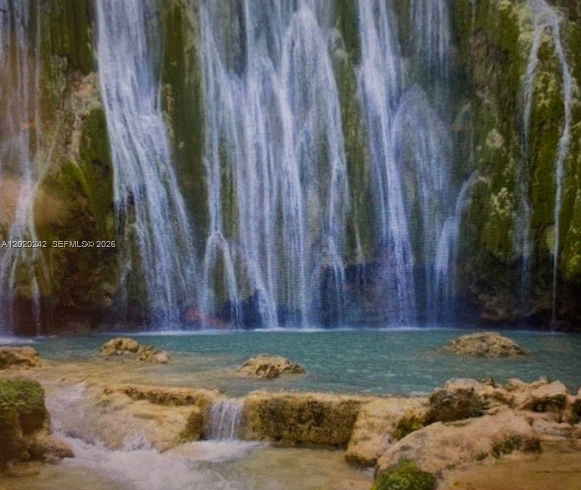 A waterfall cascades down a mossy rock face into a small, clear turquoise pool — SAMANA, SANCHEZ-LOS ROBALOS, FL, FL