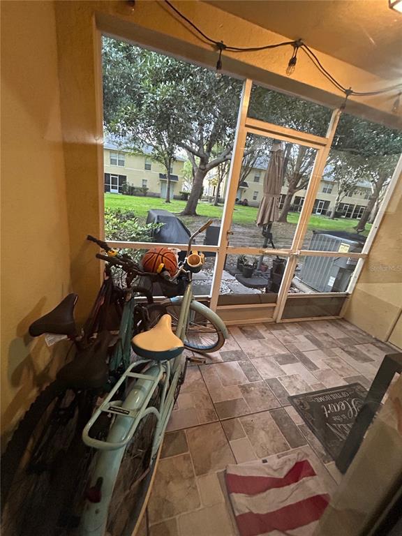 A concrete walkway leads to a covered porch with two chairs and a rooster statue — 10916 KEYS GATE DRIVE, RIVERVIEW, FL