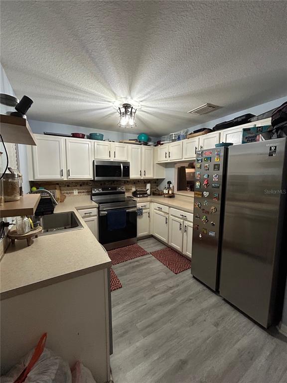 A screened-in porch with tiled flooring contains two bicycles and overlooks a grassy courtyard — 10916 KEYS GATE DRIVE, RIVERVIEW, FL