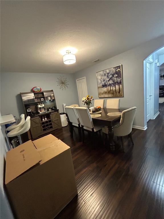 A kitchen features white cabinets, stainless steel appliances, a light countertop, and gray wood-look flooring — 10916 KEYS GATE DRIVE, RIVERVIEW, FL