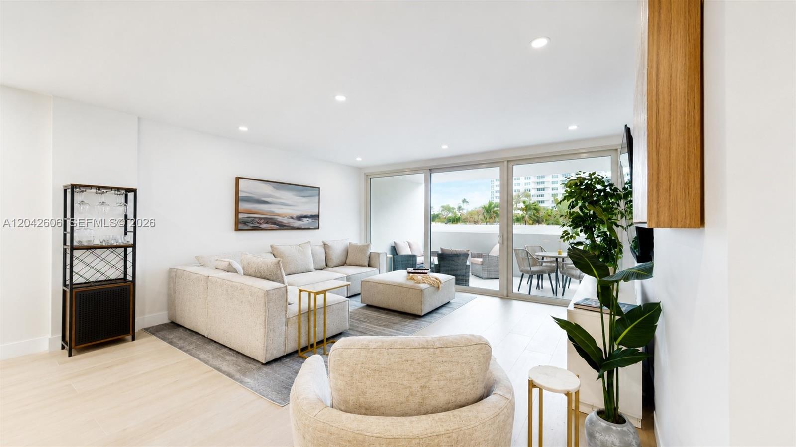A modern living room features a sectional sofa, a lounge chair, and a balcony view — 177 Ocean Lane Dr # 213, Key Biscayne FL 33149, KEY BISCAYNE, FL