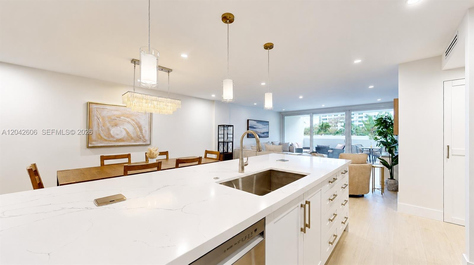 A modern kitchen features a white quartz island with a sink and pendant lighting — 177 Ocean Lane Dr # 213, Key Biscayne FL 33149, KEY BISCAYNE, FL