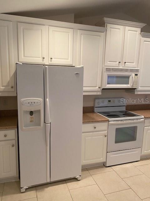 A white kitchen features white cabinetry, a side-by-side refrigerator, and a white electric range — 28 FIRETHORN LANE, PALM COAST, FL