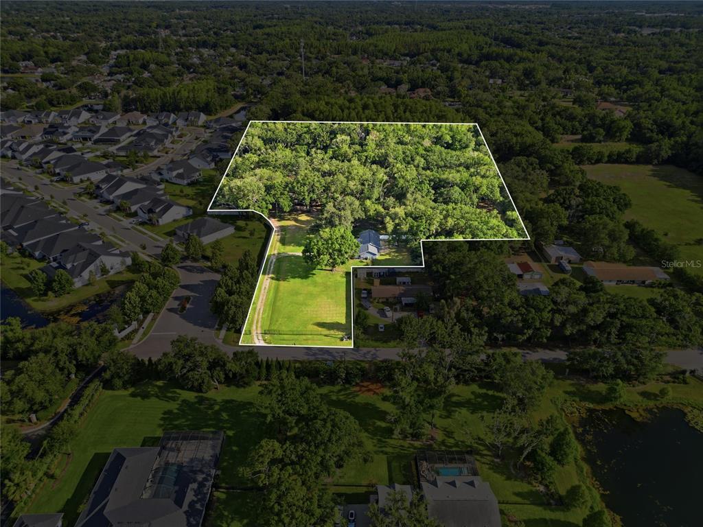 An aerial view shows a large, irregularly shaped residential lot with a house and trees — 7608 COPELAND ROAD, ODESSA, FL