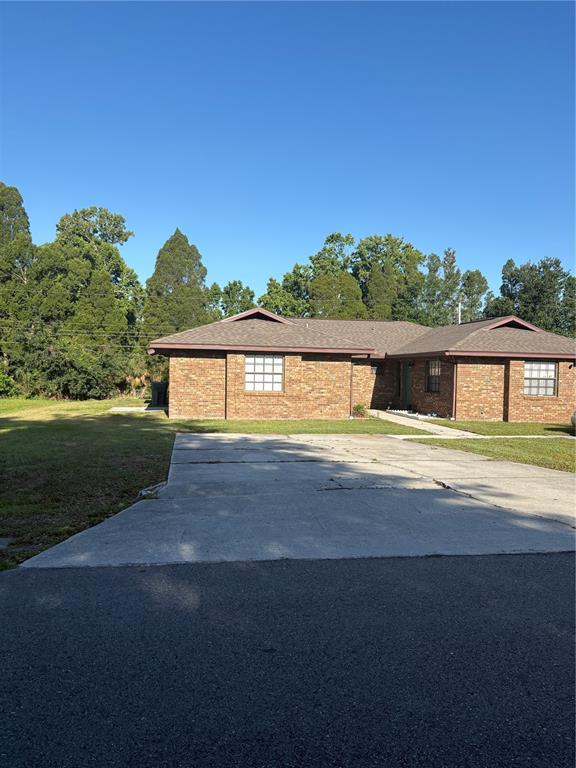 A single-story brick house with a concrete driveway and a hip roof — 3122 JULIA COURT, LAKELAND, FL