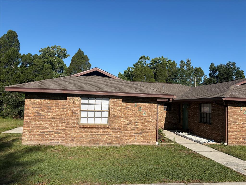 A single-story brick house with a brown shingled roof and a front walkway — 3122 JULIA COURT, LAKELAND, FL