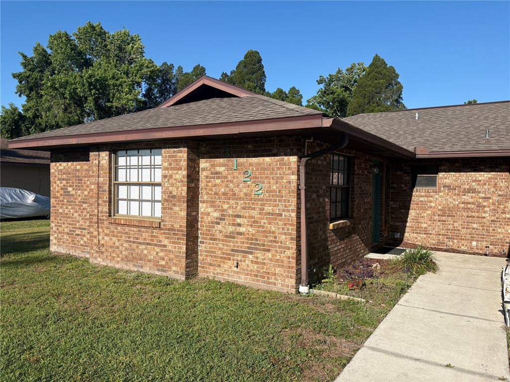 A single-story brick house with a brown shingled roof and a concrete walkway — 3122 JULIA COURT, LAKELAND, FL