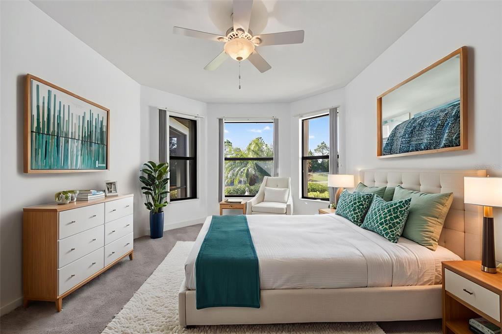A bedroom features a bed with green pillows, a white dresser, and three large windows — 12826 DEL CORSO LOOP, BRADENTON, FL