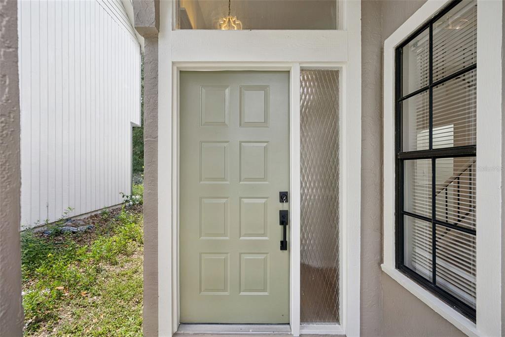 A light green front door with a side window and a black handle set — 1866 SUMMIT CHASE AVENUE, APOPKA, FL