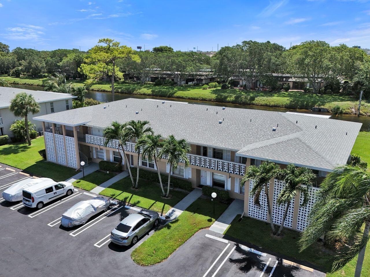 An aerial view of a two-story apartment building with a parking lot and a canal — 1050 Citrus Way # 203, Delray Beach FL 33445, DELRAY BEACH, FL