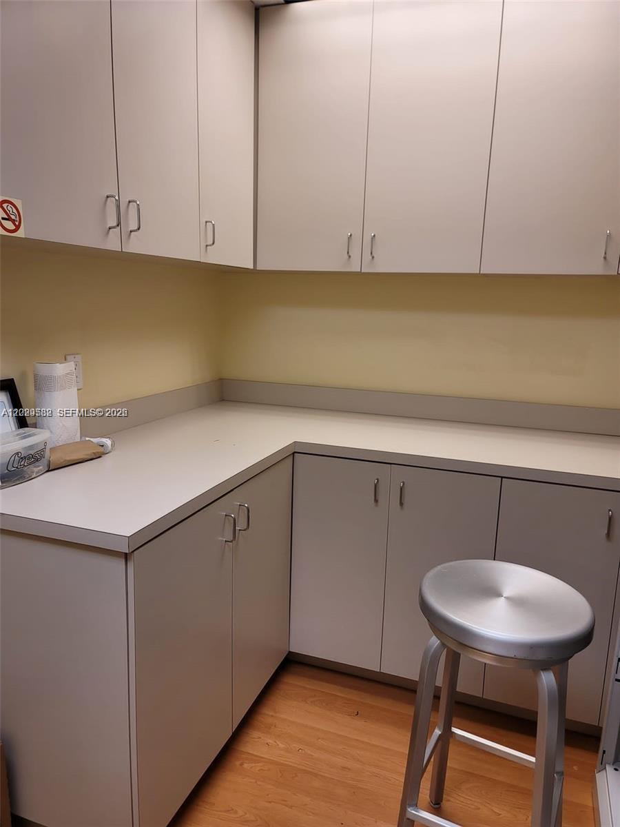 A small room features light-colored cabinetry, a white countertop, and a metal stool — 12905 SW 132nd St # 6, Miami FL 33186, MIAMI, FL