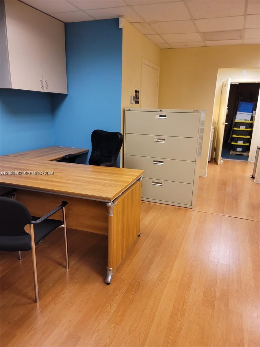 An office space features a wood-grain desk, a four-drawer filing cabinet, and light-colored flooring — 12905 SW 132nd St # 6, Miami FL 33186, MIAMI, FL