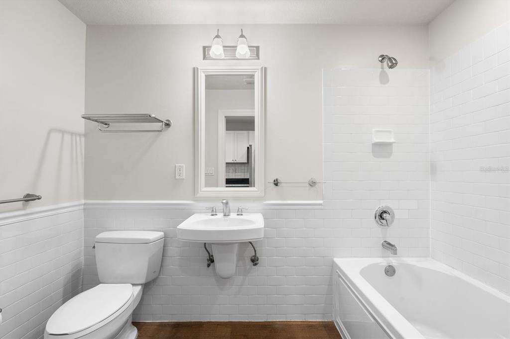 A bathroom features a wall-mounted sink, a toilet, and a bathtub with white subway tile — 536 BAHIA BEACH BOULEVARD UNIT 233C, RUSKIN, FL