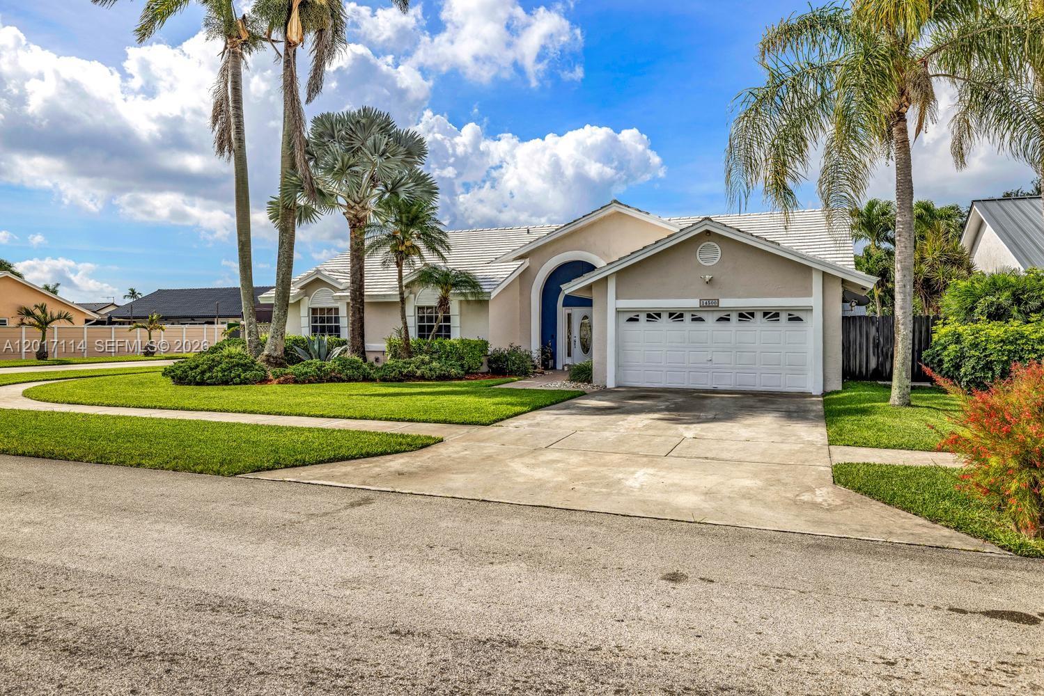 A single-story house with a white garage, arched entryway, and palm trees in the yard — 14500 SW 161st St, Miami FL 33177, MIAMI, FL