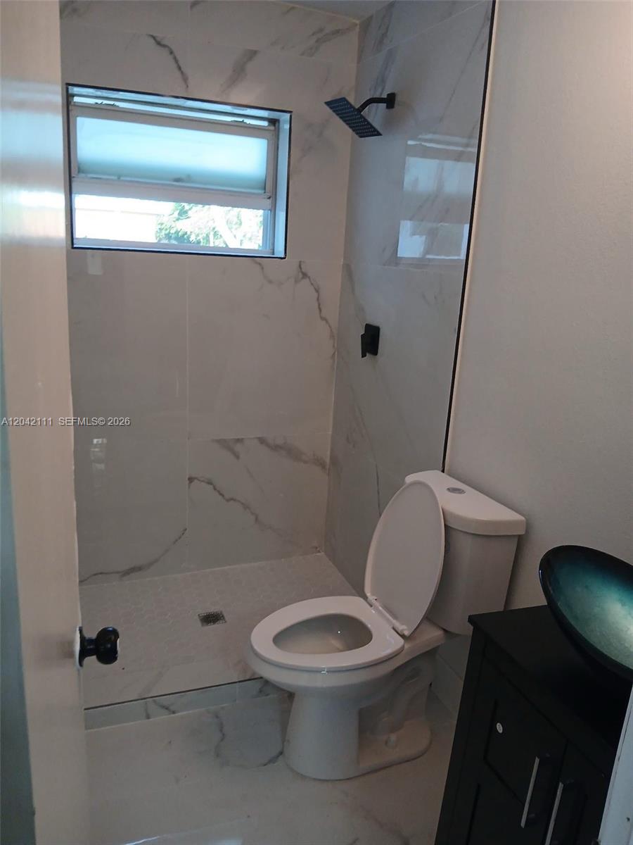 A bathroom features a walk-in shower with marble-look tile, a toilet, and a vessel sink — 560 NW 188th St # 1, Miami Gardens FL 33169, MIAMI GARDENS, FL
