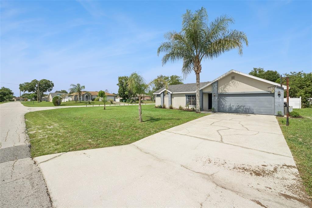 A single-story house with a gray garage and a palm tree in the front yard — 2620 E DORCHESTER DR, DELTONA, FL