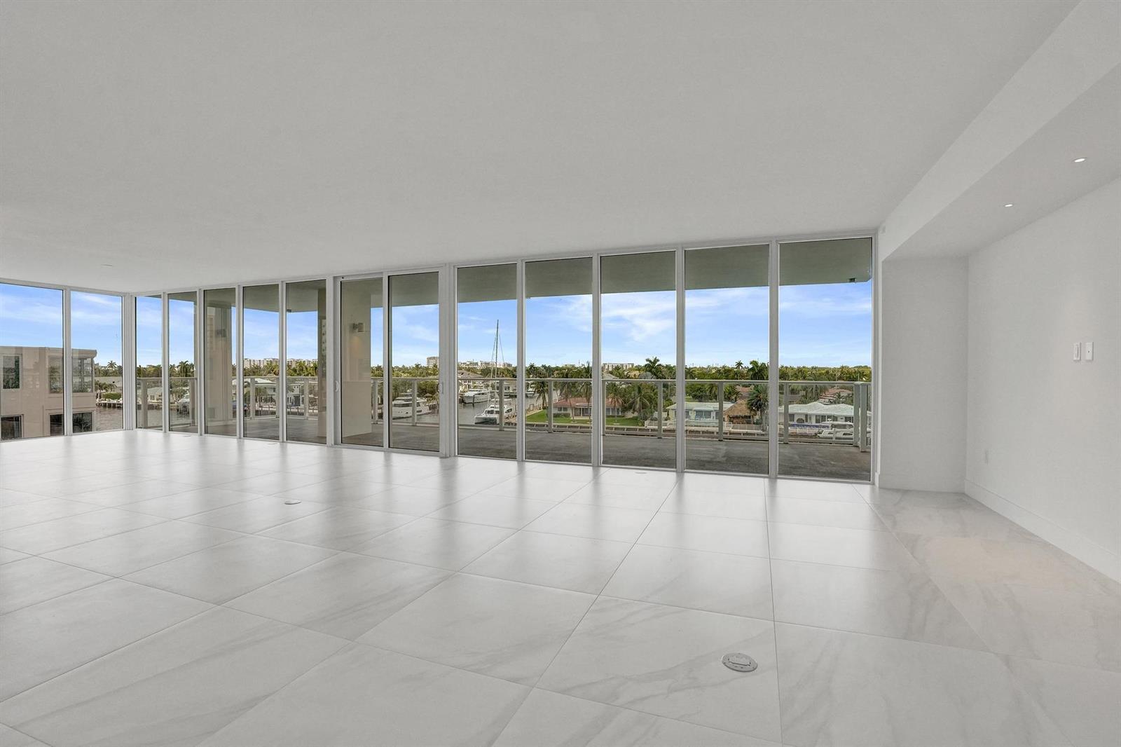 An empty room with white marble floors and floor-to-ceiling windows overlooking a waterfront view — 407 N Riverside Drive # 401, Pompano Beach FL 33062, POMPANO BEACH, FL