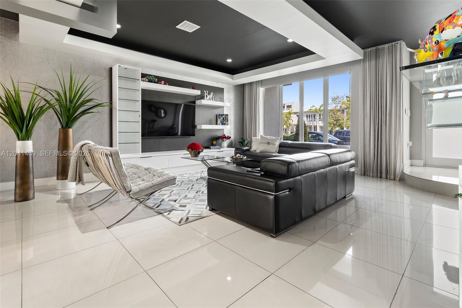 A modern living room features a black tray ceiling, white tile floors, and leather furniture — 6306 NW 104th Path, Doral FL 33178, DORAL, FL