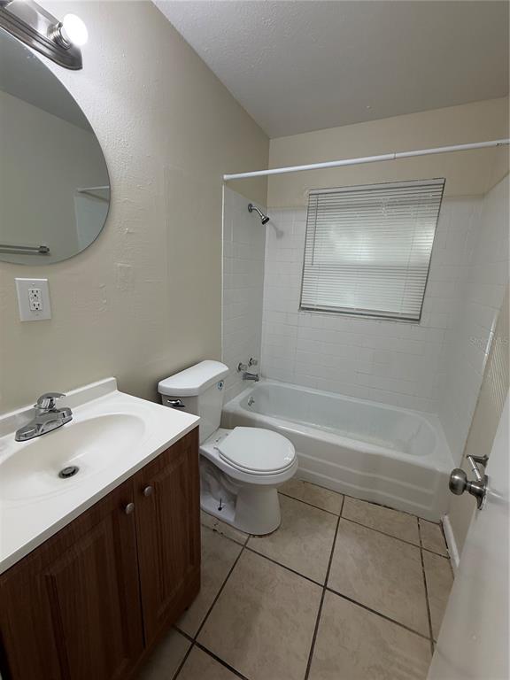A bathroom features a vanity with a sink, a toilet, and a tiled shower-tub combination — 1323 BRAEBURY DRIVE, LEESBURG, FL