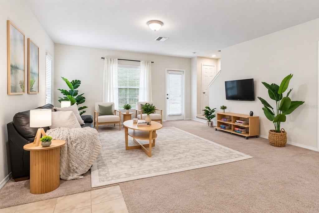 A living room features a black sofa, two armchairs, a coffee table, and a television — 4741 CHATTERTON WAY, RIVERVIEW, FL