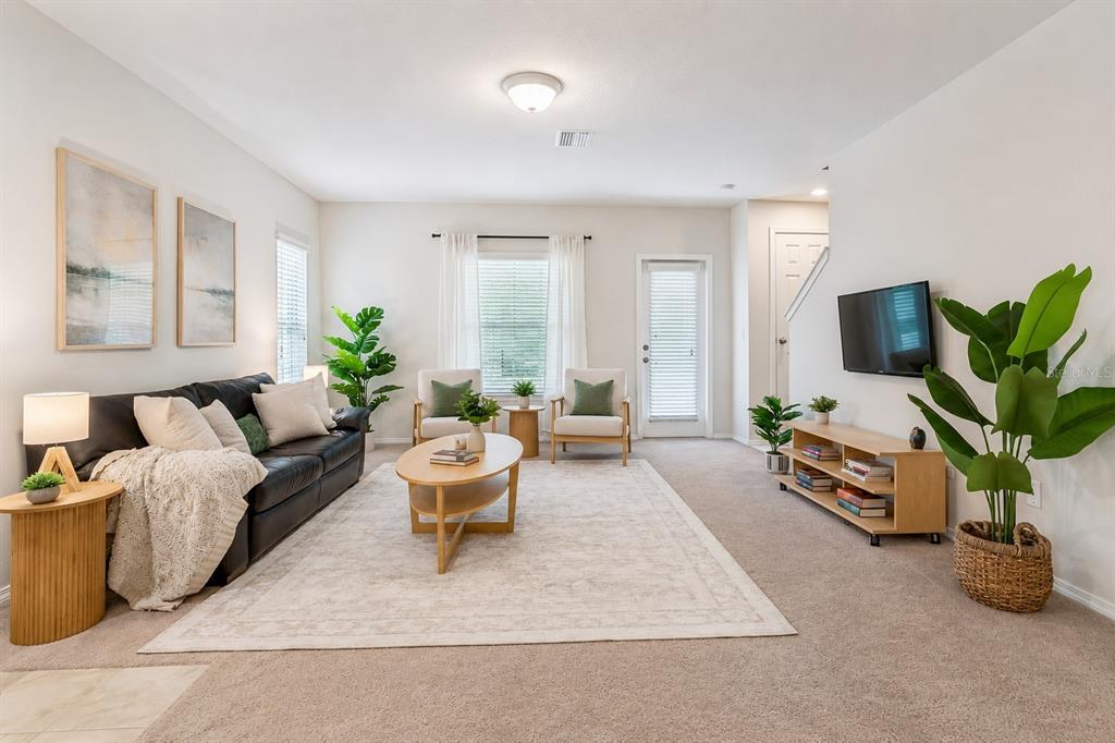 A living room features a dark sofa, two armchairs, a coffee table, and a television — 4741 CHATTERTON WAY, RIVERVIEW, FL