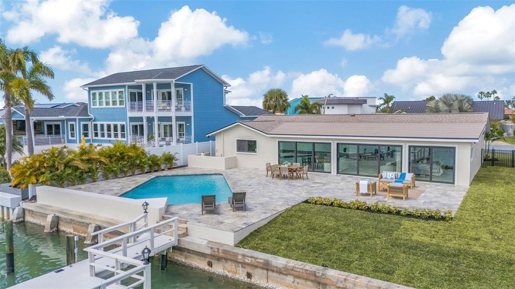 A single-story house with a paved driveway, two palm trees, and a white garage door — 825 116TH AVENUE, TREASURE ISLAND, FL