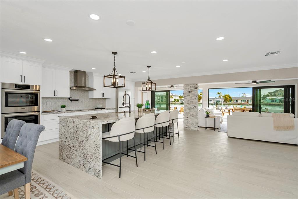 A single-story house with a tan exterior, a covered entryway, and palm trees in the yard — 825 116TH AVENUE, TREASURE ISLAND, FL