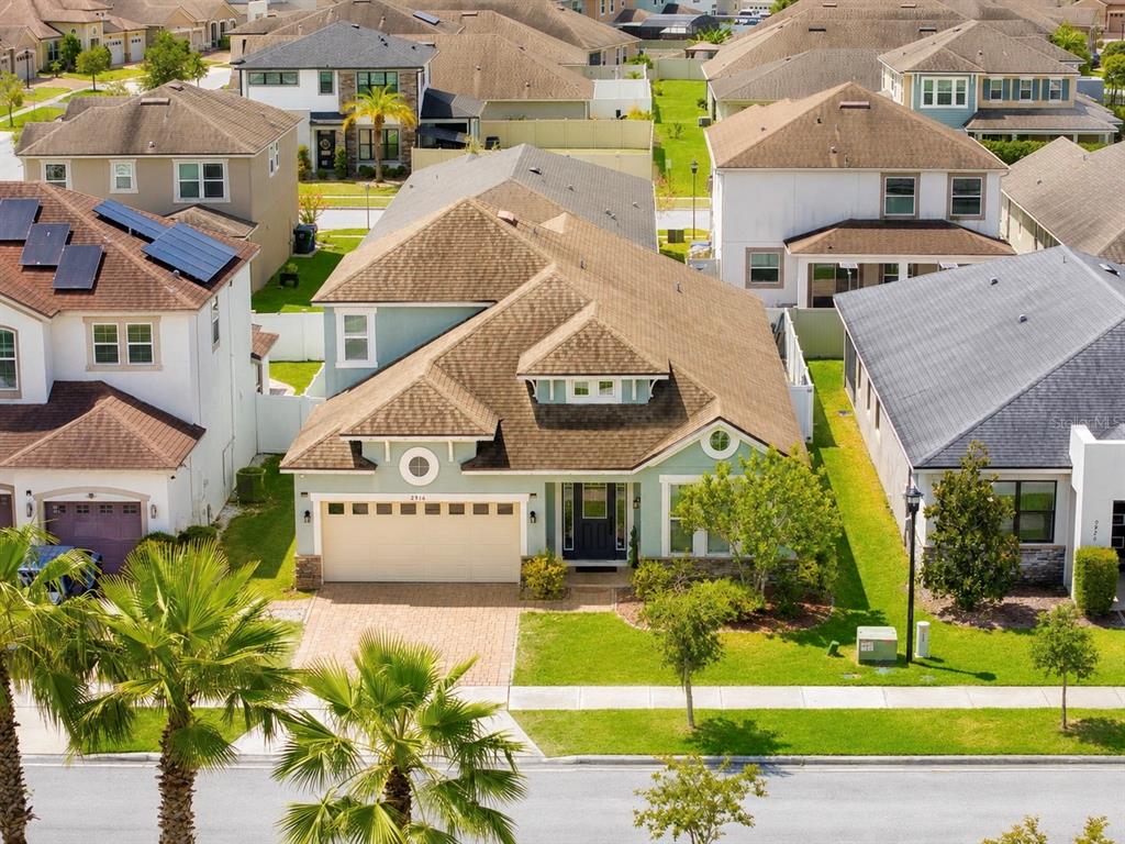 An aerial view of a light green suburban house with a tan roof and driveway — 2916 CHANTILLY AVENUE, KISSIMMEE, FL
