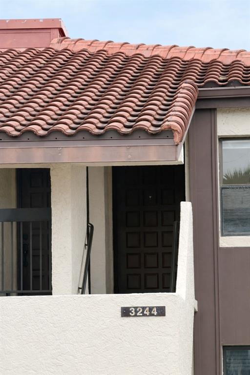 An exterior view shows a building entrance with a tiled roof and a house number — 3244 CANDLE RIDGE DRIVE UNIT 202, ORLANDO, FL
