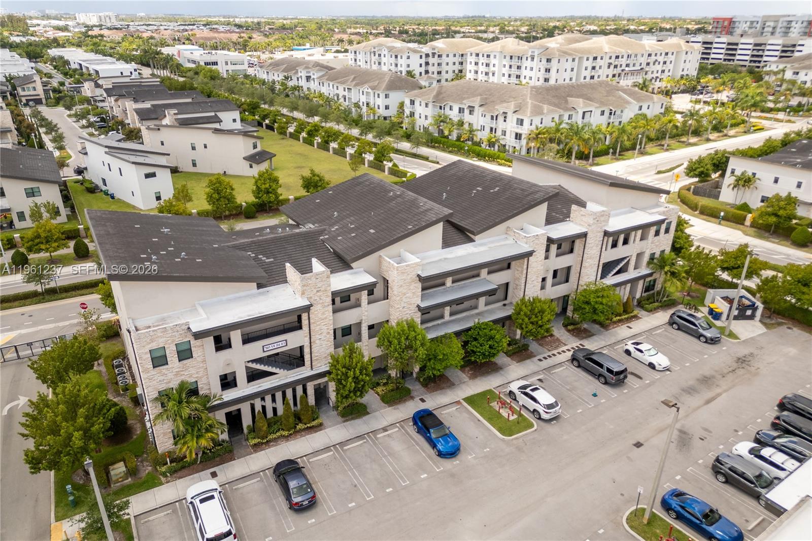 An aerial view shows a multi-story apartment building with a parking lot in front — 7831 NW 104th Ave # 32, Doral FL 33178, DORAL, FL