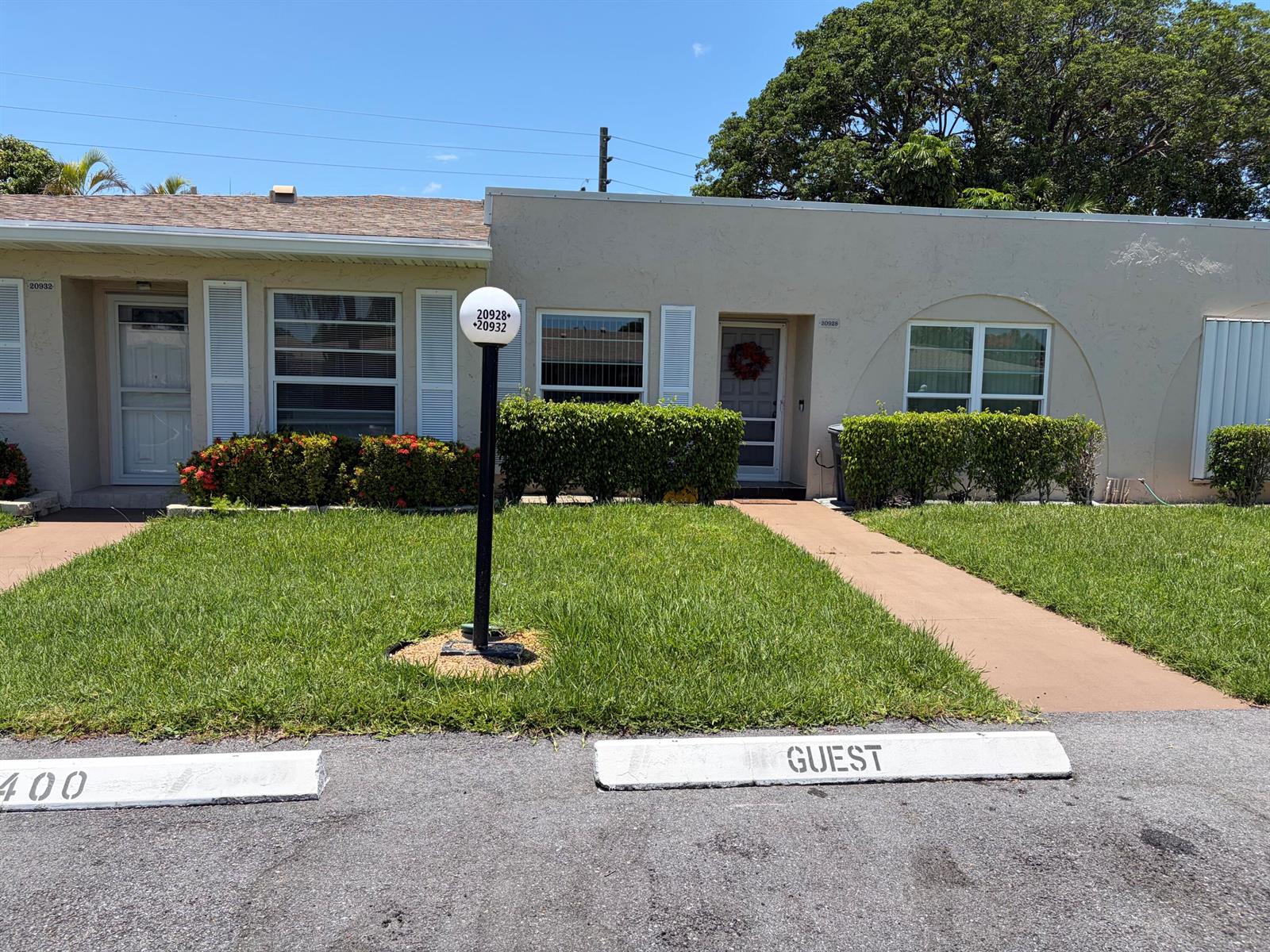 A single-story duplex with beige stucco walls, two front doors, and a guest parking space — 20928 Sedgewick Drive # 399, Boca Raton FL 33433, BOCA RATON, FL