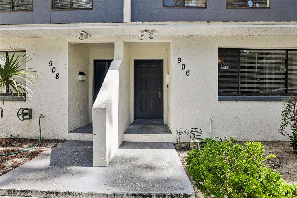 The exterior of a two-story residential building features two adjacent unit entrances with dark doors — 904 SUMTER STREET, LEESBURG, FL