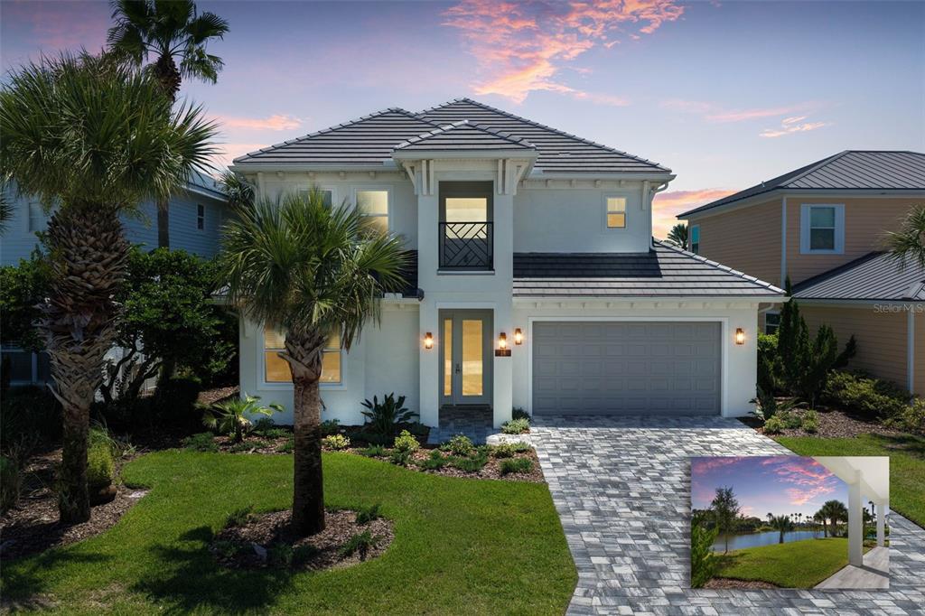 A two-story house with a gray tile roof, white stucco exterior, and a paved driveway — 18 CINNAMON BEACH WAY, PALM COAST, FL
