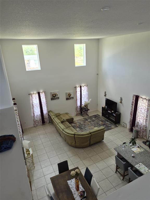 A high-angle view of an open-concept living and dining area with high ceilings and tile floors — 1482 FLATWOOD STREET, ST CLOUD, FL