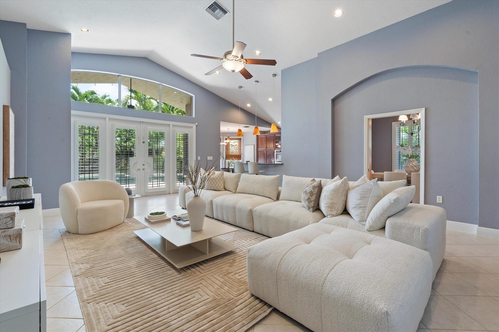 A living room features a large white sectional, a curved armchair, and vaulted ceilings — 19633 Estuary Drive, Boca Raton FL 33498, BOCA RATON, FL