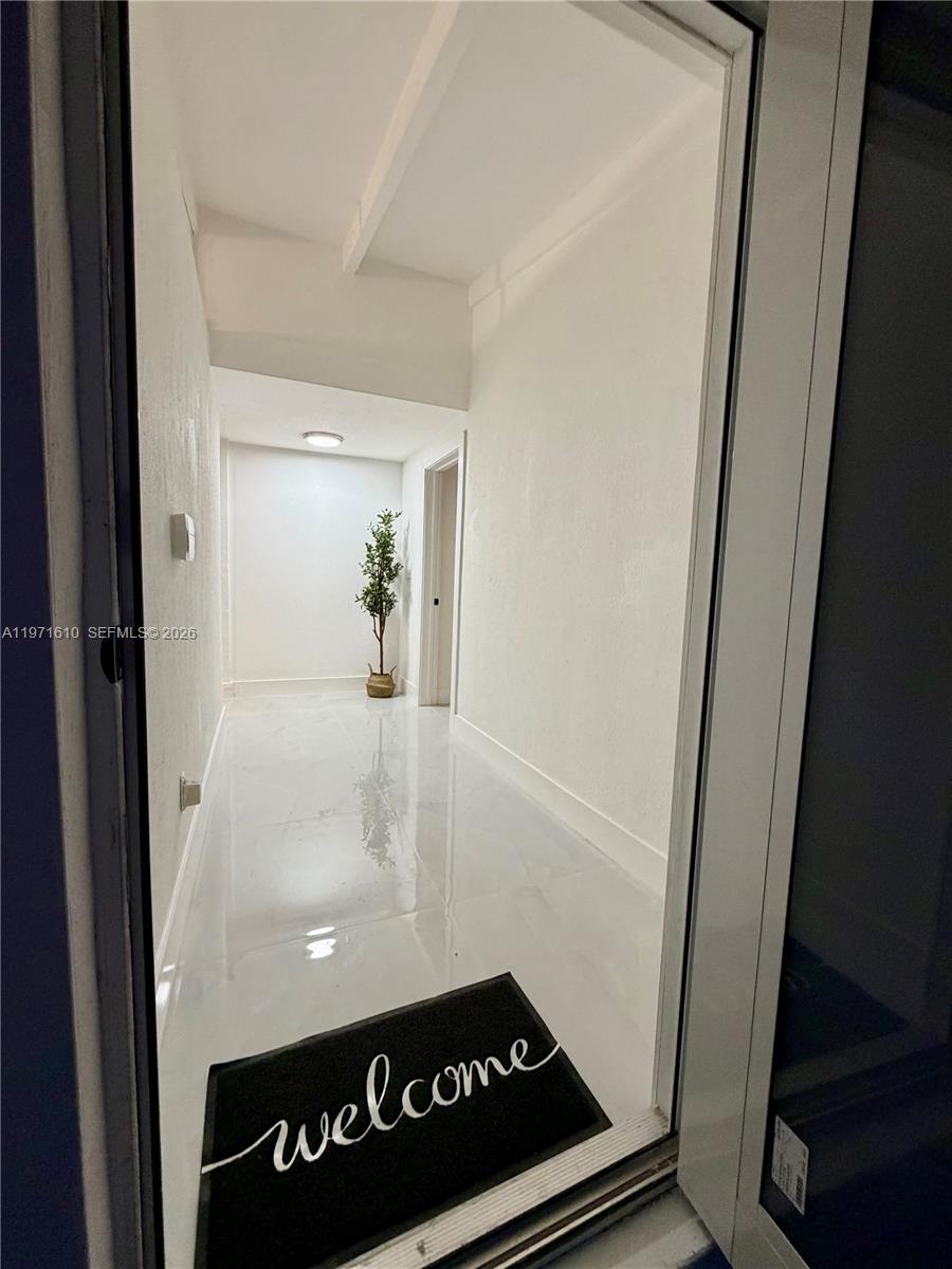 A view through a doorway shows a bright hallway with white walls and tile flooring — 19730 NW 3rd Ct, Miami Gardens FL 33169, MIAMI GARDENS, FL