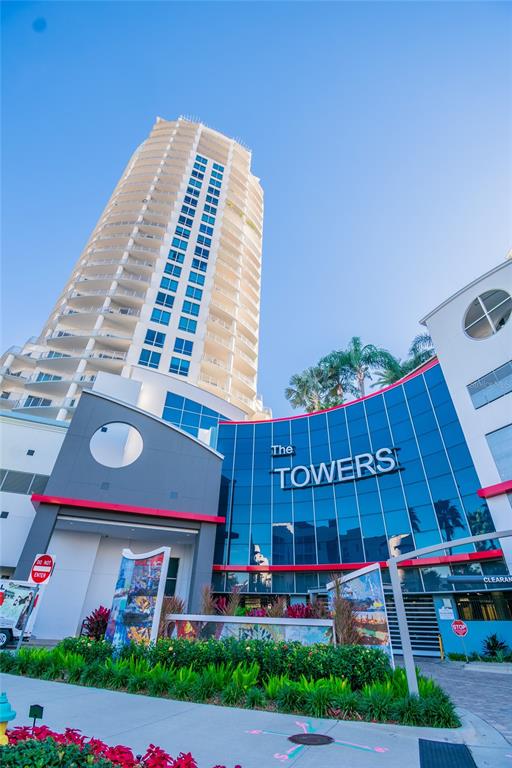A tall, modern residential high-rise building features a curved glass facade labeled The Towers — 449 S 12TH STREET UNIT 1904, TAMPA, FL