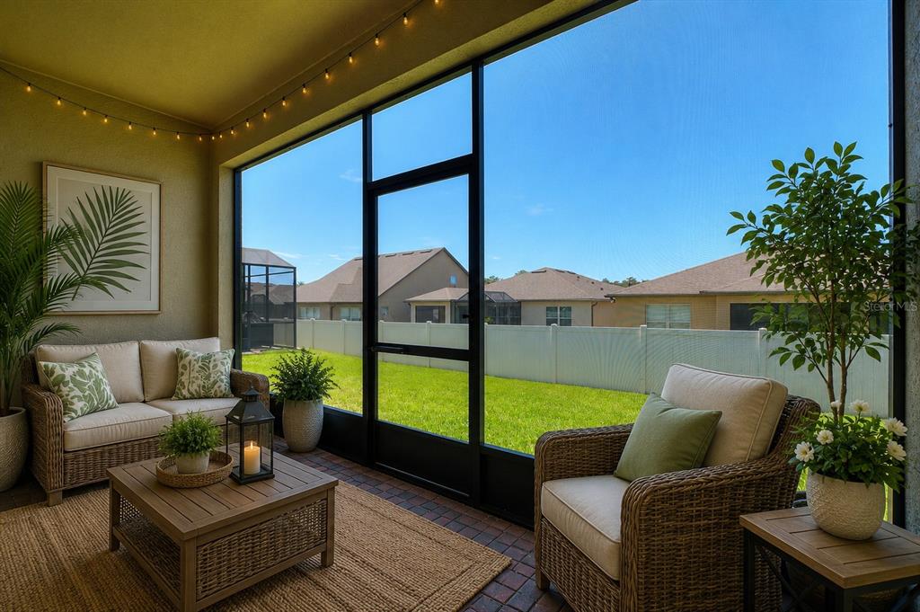 A screened-in patio features wicker furniture, a brick floor, and a view of a backyard — 406 TORTOSA COURT, DAVENPORT, FL