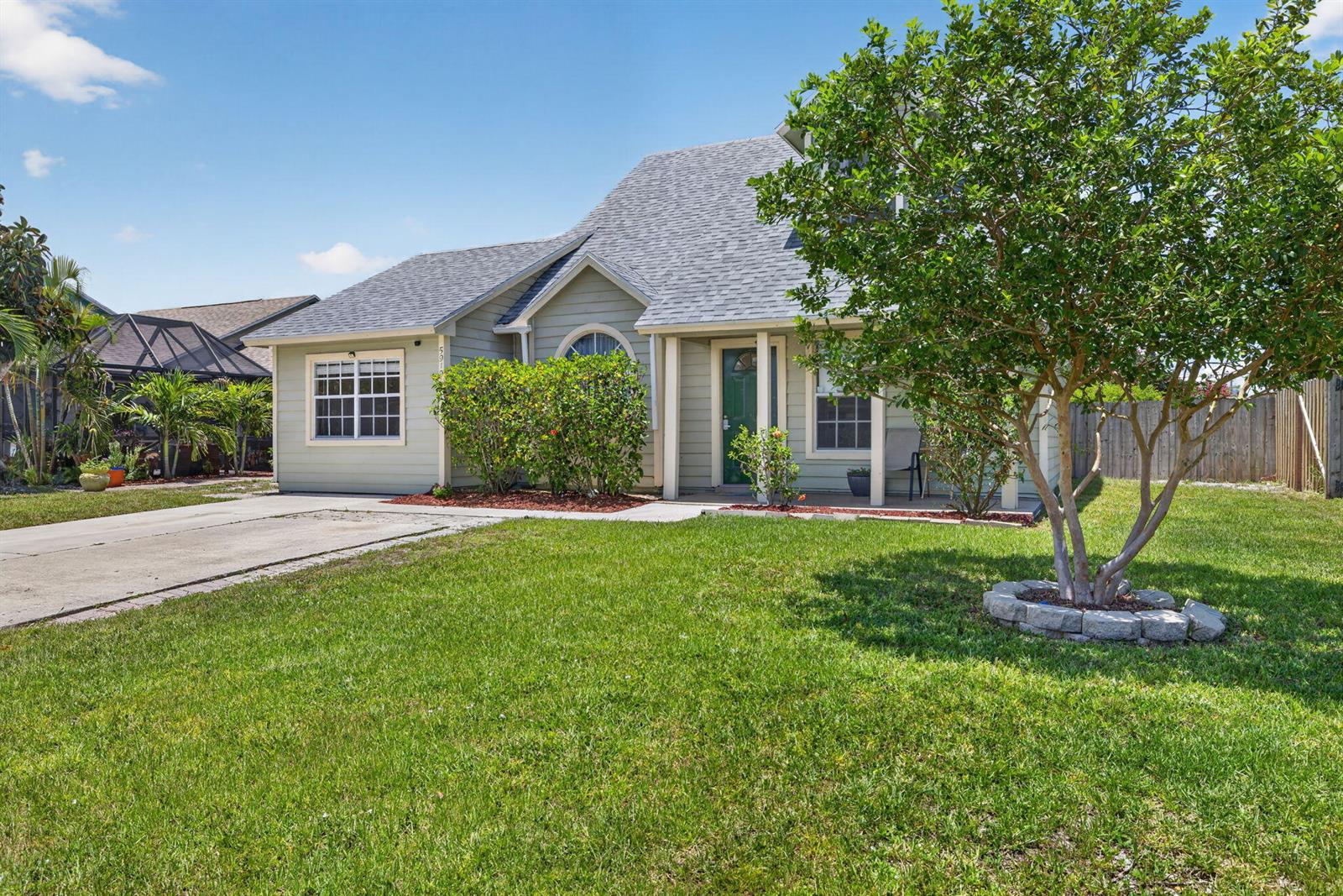 A light green single-story house with a gray shingled roof and a front lawn — 5919 SE Pine Drive, Stuart FL 34997, STUART, FL